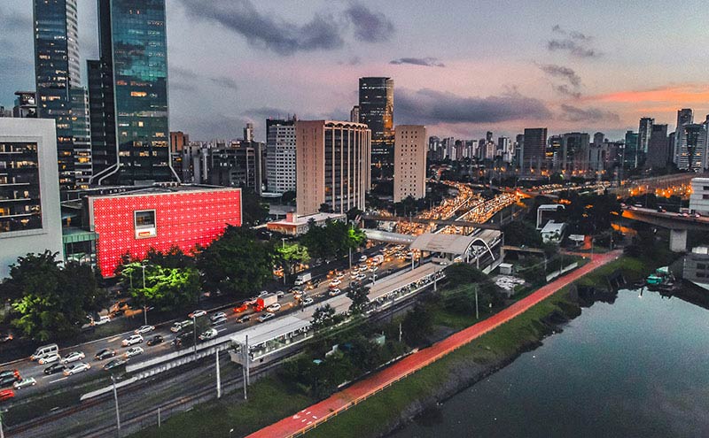 A bustling city skyline at dusk, adorned with towering buildings and illuminated by the glow of traffic below. A bustling city skyline at dusk, adorned with towering buildings and illuminated by the glow of traffic below.
